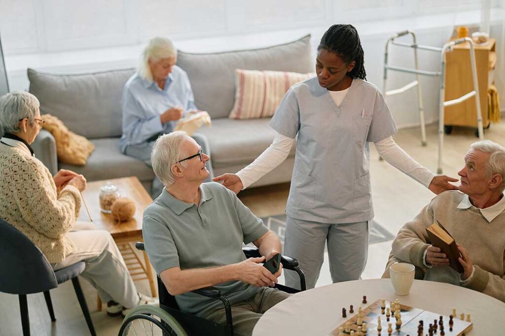 A caregiver and senior resident sitting together reviewing a document in a comfortable residential setting.