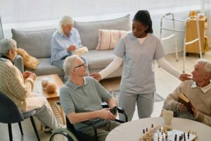 A caregiver and senior resident sitting together reviewing a document in a comfortable residential setting.